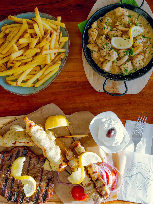Gedeckter Tisch mit Souvlaki, Steak, Pommes und Tzatziki